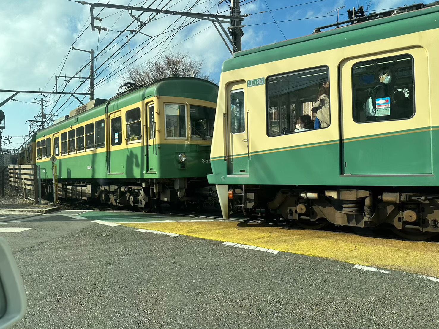Enoden green-and-yellow trains passing on the single-track line near Kamakura